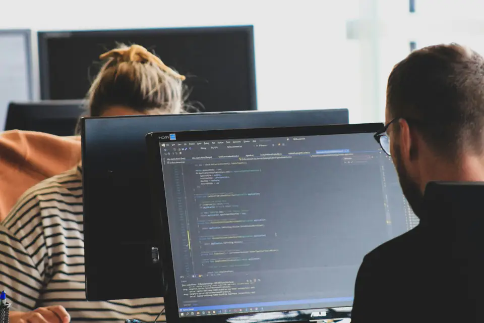 Dos personas programando delante de sus pantallas